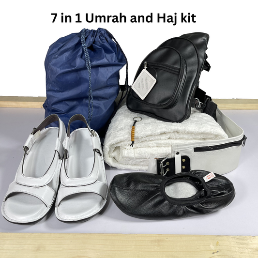 7-in-1 Umrah and Haj kit with various items including a blue drawstring bag, black shoes, white sandals, and a black seat cover on a light gray background.